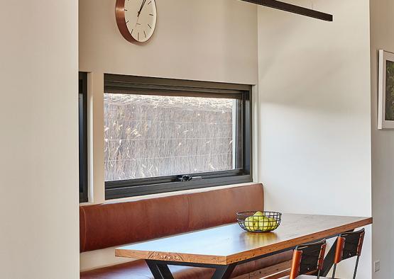 a table with chairs and a clock in the corner of a room