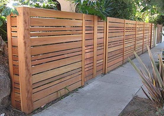 a wooden fence with a fence in the background