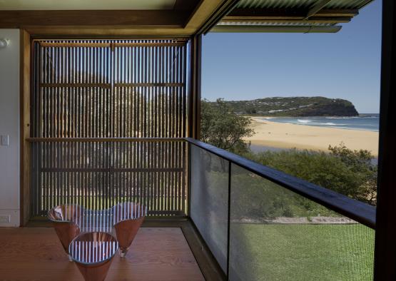 a balcony with a view of the beach and trees