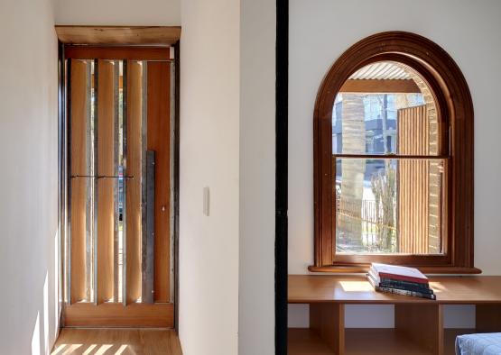 a hallway with a wooden door and a bench