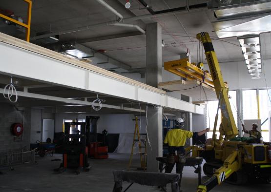 a man standing in a room with a crane