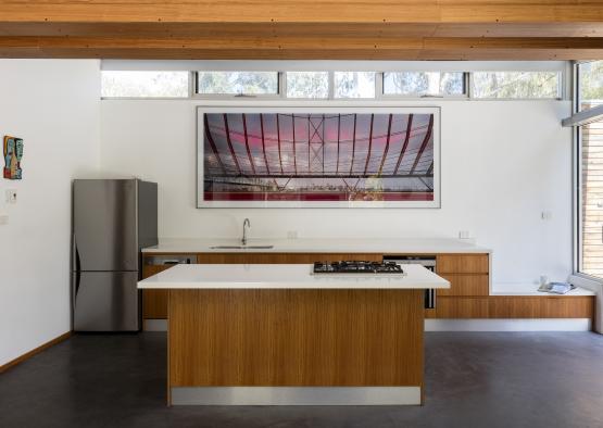 a kitchen with a large picture on the wall