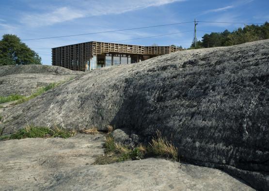 a building with a wooden structure on top of a large rock