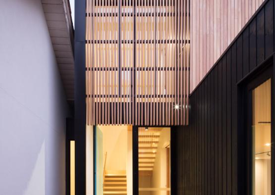 a building with a wood wall and a glass door