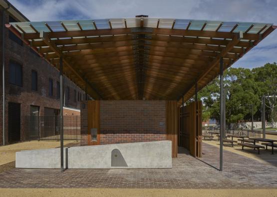 a covered area with a brick wall and a concrete slab