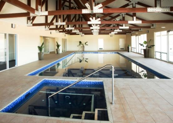 a indoor swimming pool with a metal railing