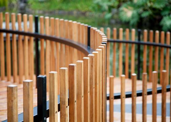a wooden fence with a black metal railing