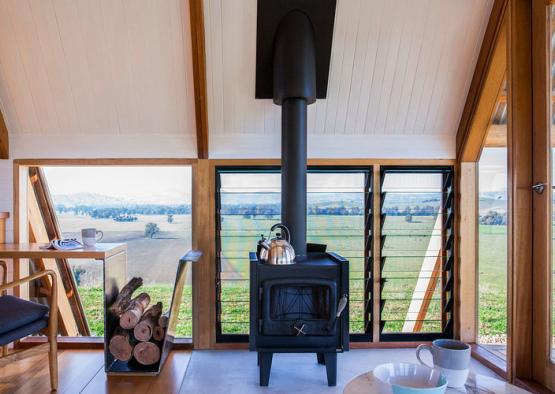 a wood stove in a room with windows and a view of the valley
