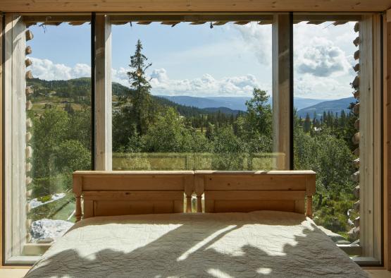 a bed with a view of trees and mountains