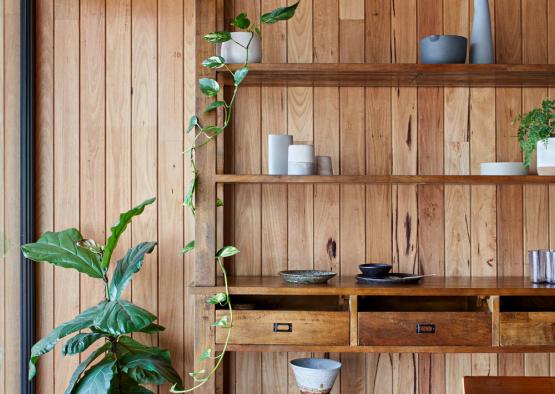 a wood shelf with a table and a plant