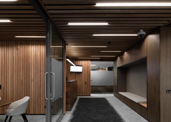 a hallway with a black rug and a wood paneled ceiling