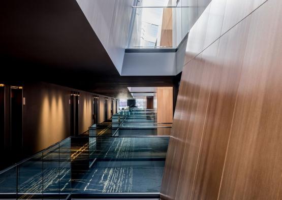 a hallway with glass railings and a glass wall
