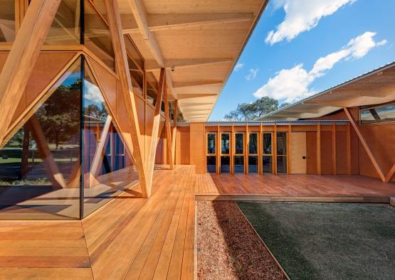 a building with a wooden deck and a glass wall