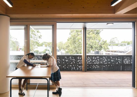 two girls writing on a table