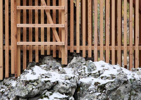 a wooden fence next to a rock