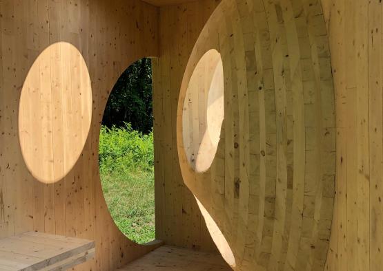 a wooden structure with round holes and a window