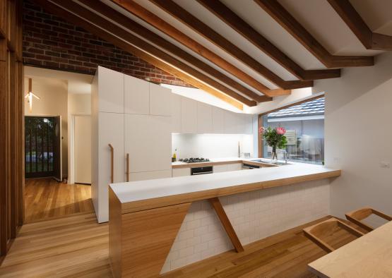 a kitchen with wood beams and a brick wall
