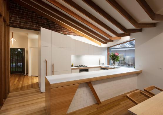 a kitchen with wood beams and a brick wall