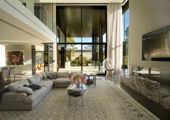 a living room with a large glass wall and a large couch