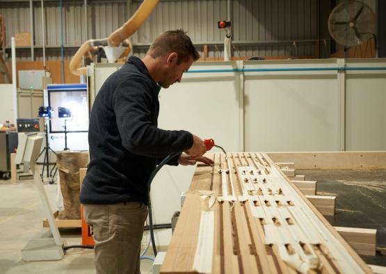 a man using a drill to cut wood