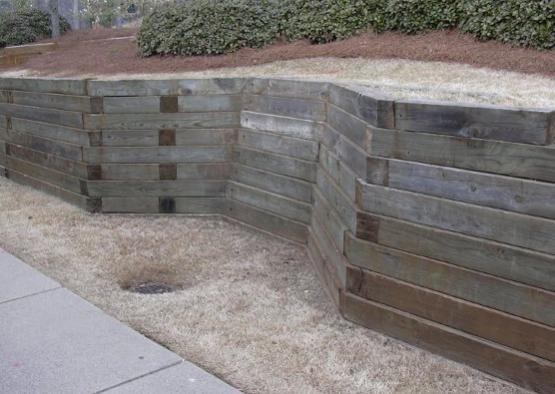 a wooden retaining wall with a hole in the ground