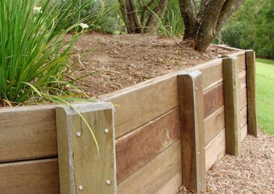 a wooden retaining wall with grass growing on it