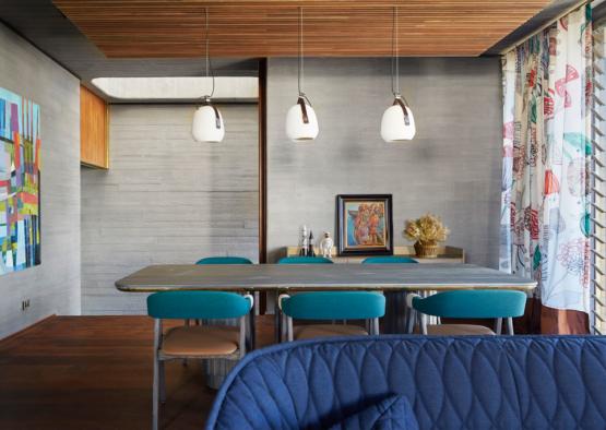 a dining table with blue chairs and a blue couch