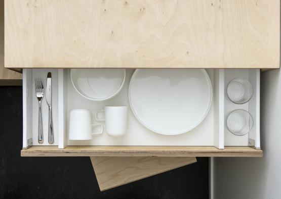 a drawer with plates and cups and silverware