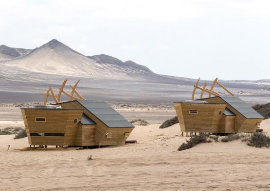 a group of wooden houses in a desert