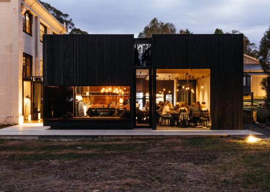 a building with a large black building with a group of people sitting at tables