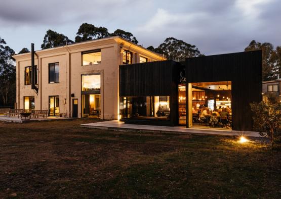 a building with a black building and a lawn