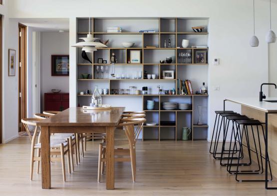 a dining table and chairs in a room with shelves