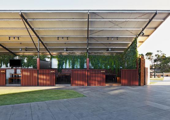 a covered patio with a roof and plants