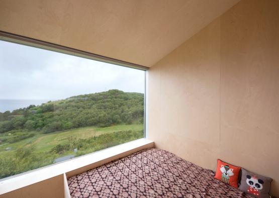 a window with a view of a forest and a bed
