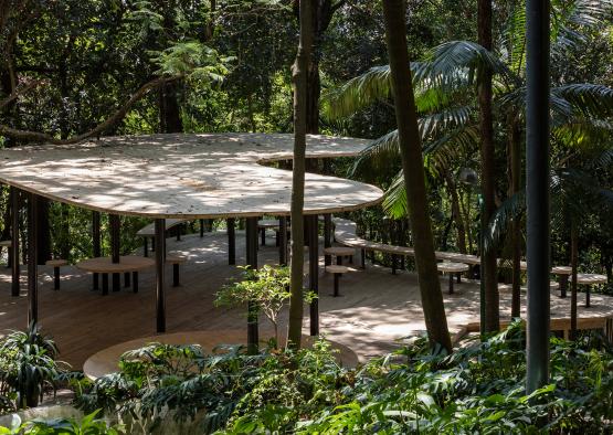 a picnic area with tables and benches in the woods