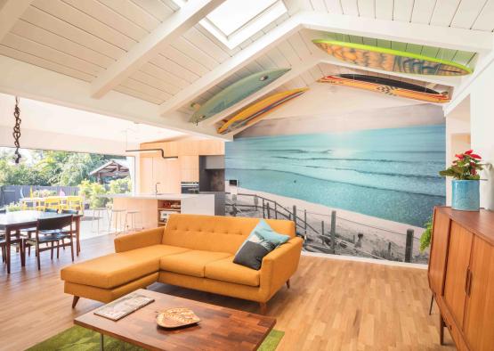 a living room with a couch and surfboard mural