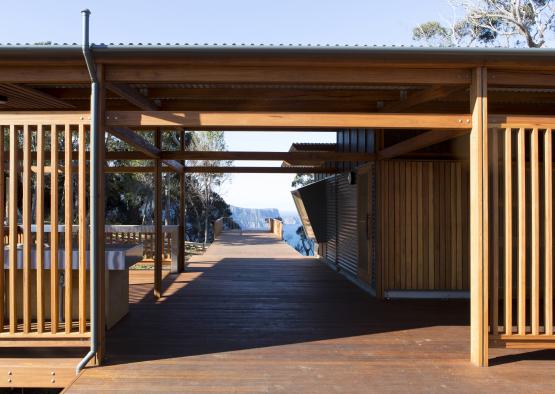 a wooden deck with a building and a view of the ocean