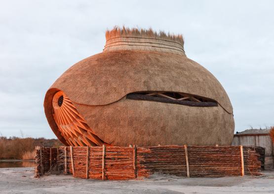 a straw house with a fence around it