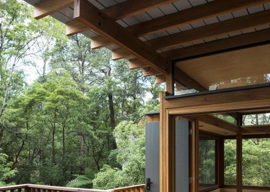 a wooden deck with a porch and a glass door