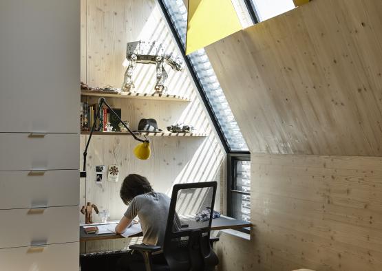 a person sitting at a desk in a room with a window