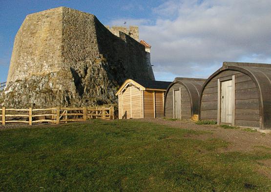 a stone structure with a large stone wall and a building