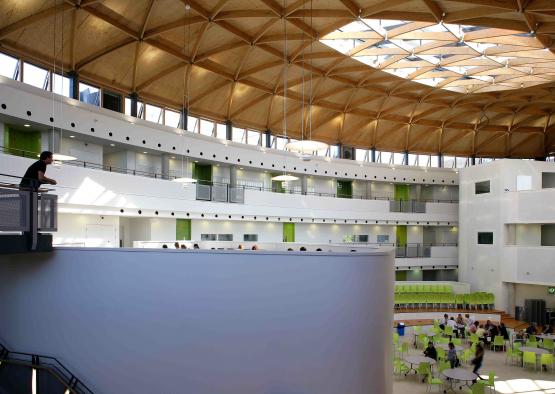 a large building with green chairs and a large white wall