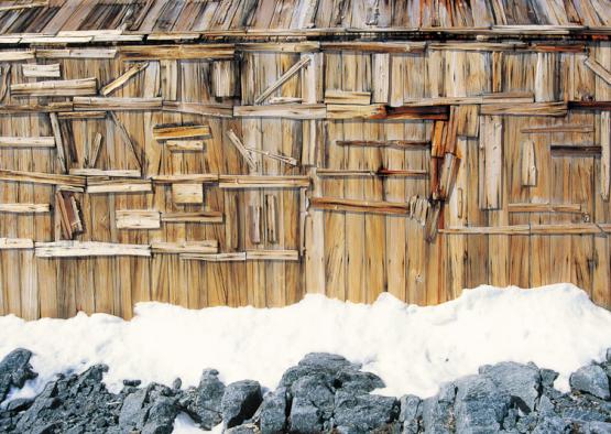 a wooden building with snow on the ground