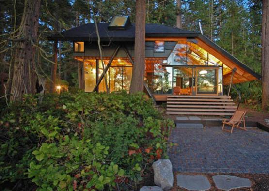 a house with a deck and a walkway in the woods