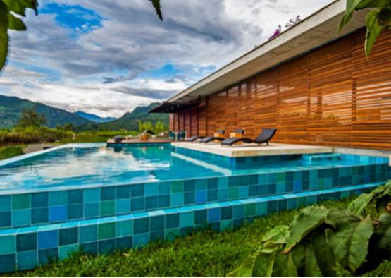 a pool with chairs and a building in the background