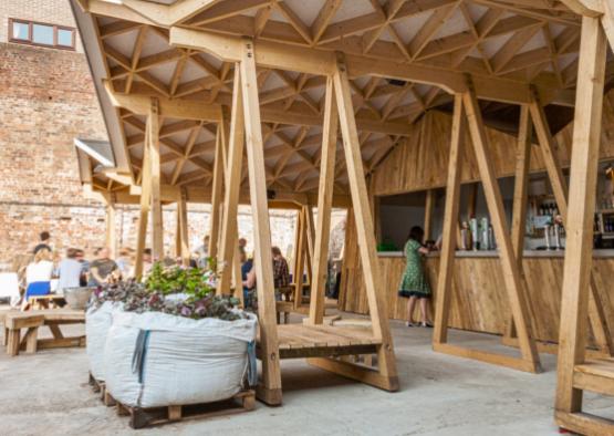 a wooden structure with people standing around