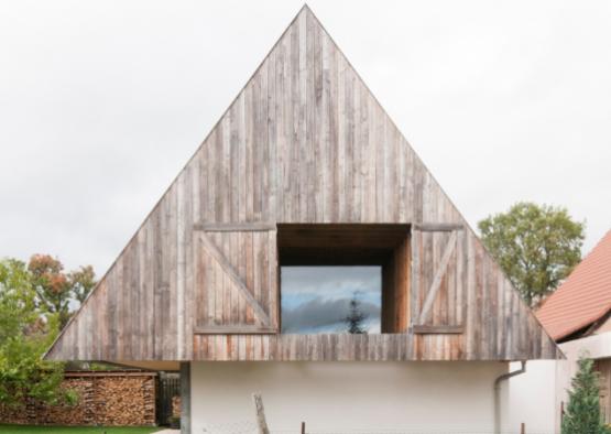 a triangular wooden building with a window