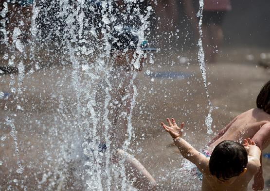 a group of children playing in a water fountain