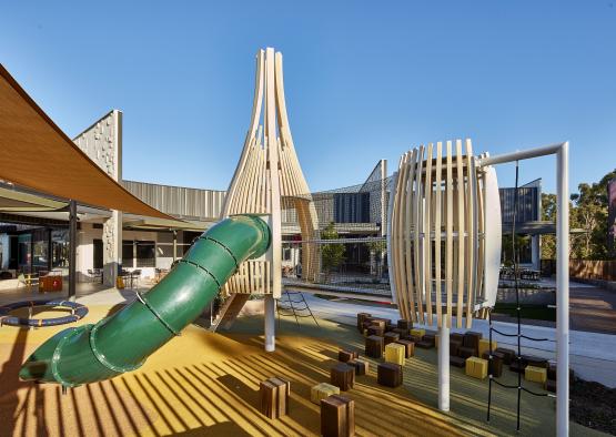 a playground with a slide and wooden structure
