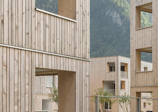 a wood building with a fence and grass